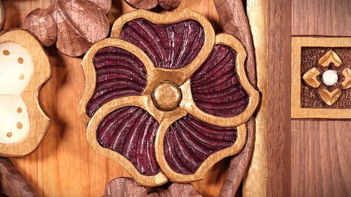 Hand-carved hollyhock flower with purple and gold paint