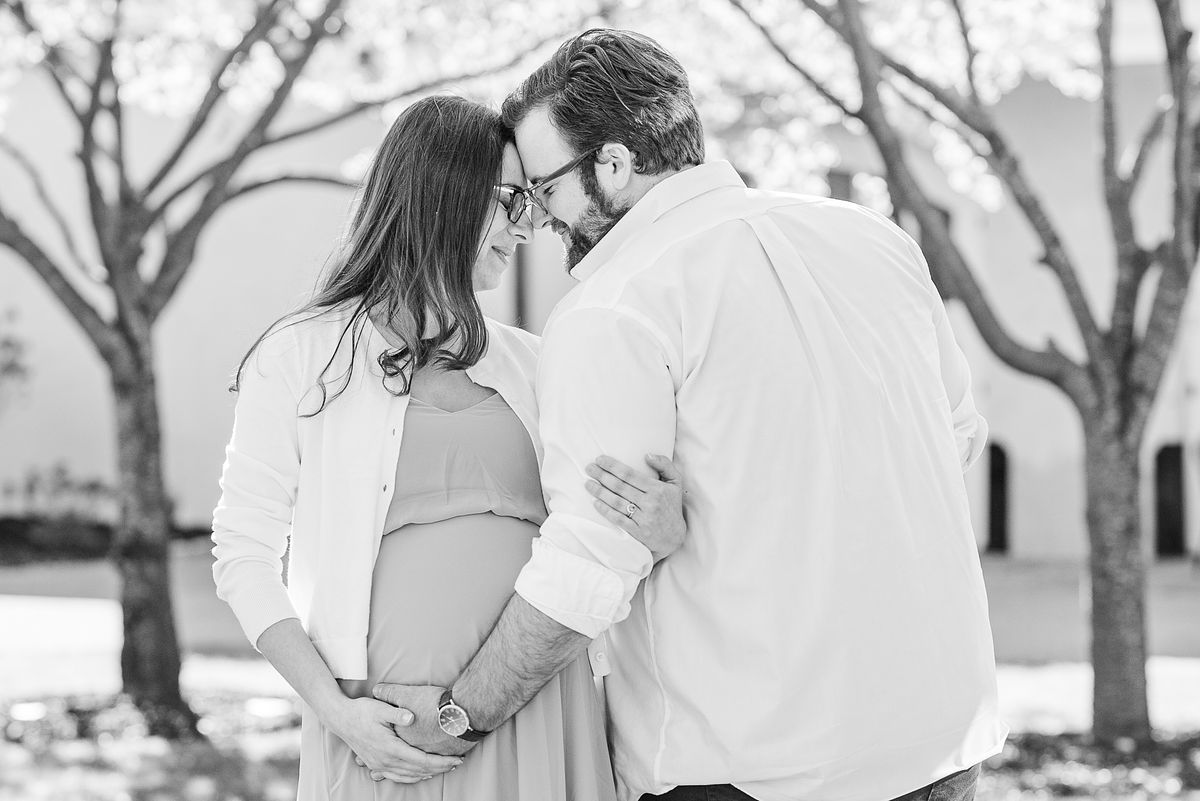 B&W of husband and wife touching foreheads and hugging her pregnant belly at The Frick