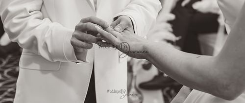 Wedding by Jermaine – black and white photo of groom putting the wedding ring on bride’s finger