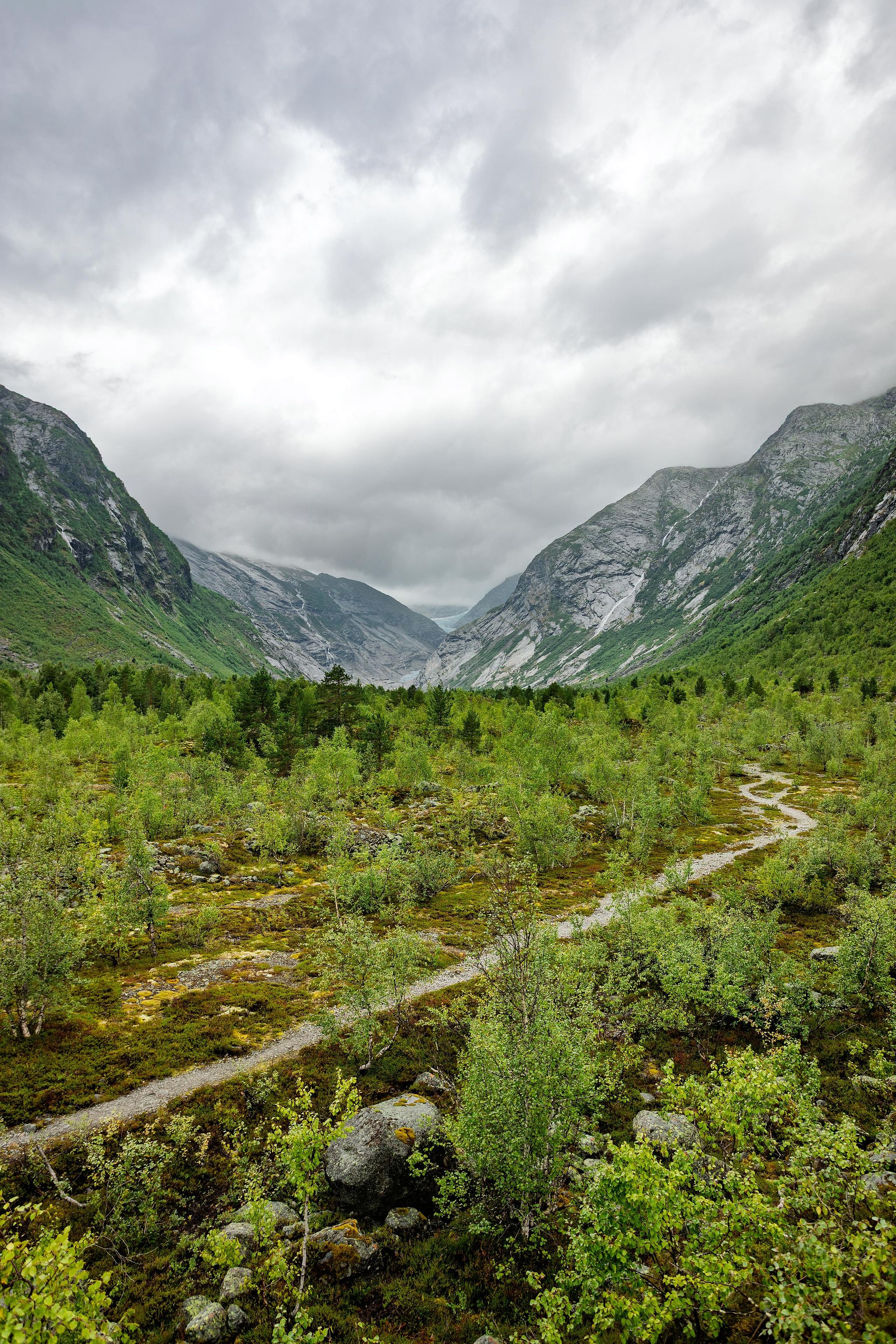 Versants végétalisés sous un ciel à trouées.