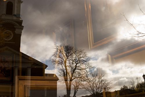 Church steeple with a mysterious gold-framed artwork in a cloudy scene on Wellesley, Massachusetts Main Street.